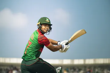 Um homem comemorando uma vitória em seu laptop enquanto símbolos de jogos flutuam ao redor, capturando a emoção dos jogos 29P.